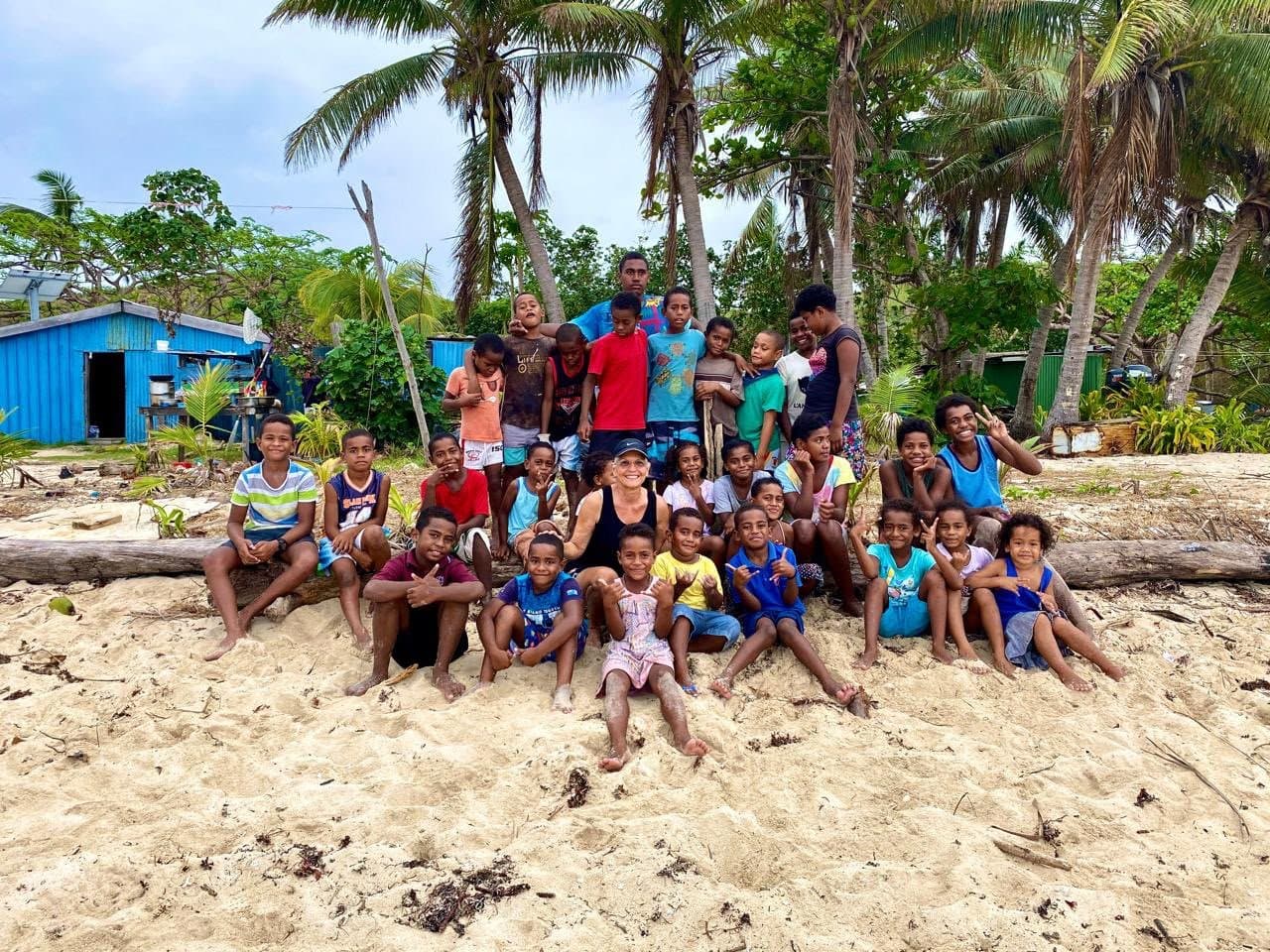 Ofelia Mercedes Méndez junto a un grupo de niños de una comunidad costera en la playa