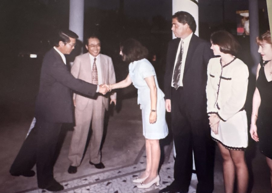 Ofelia Mercedes Méndez, de vestido claro, saluda a un invitado a la entrada del concesionario mientras el resto del grupo espera su turno la noche de la inauguración